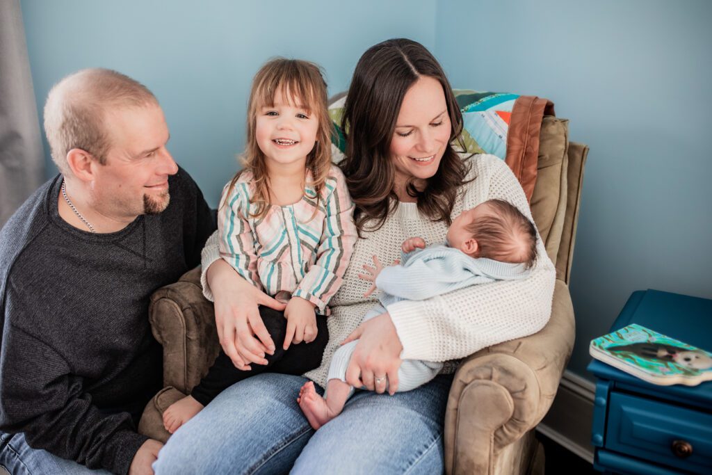 Family of 4 snuggled on a chair. 